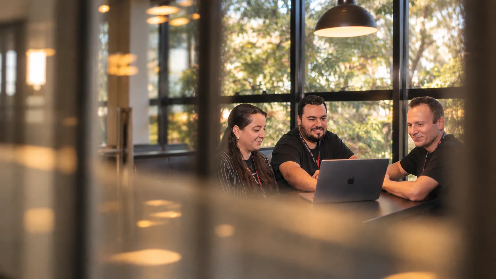 Equipe Bangboo em reunião ao redor de um notebook